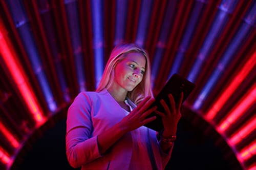 Businesswoman with tablet pc against high tech lights background