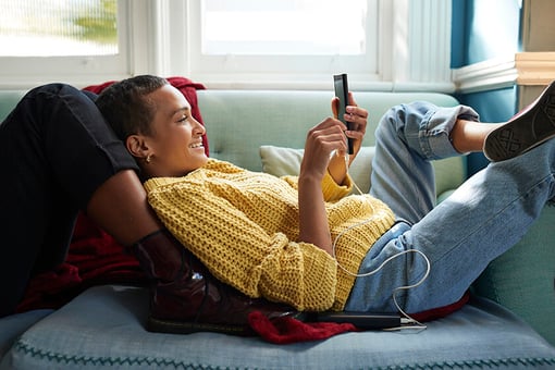 woman laying on couch looking at phone woman laying on couch looking at phone