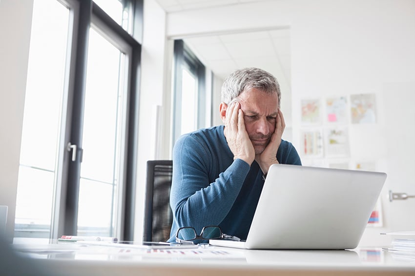 Homme qui regarde l'écran de son ordinateur portable