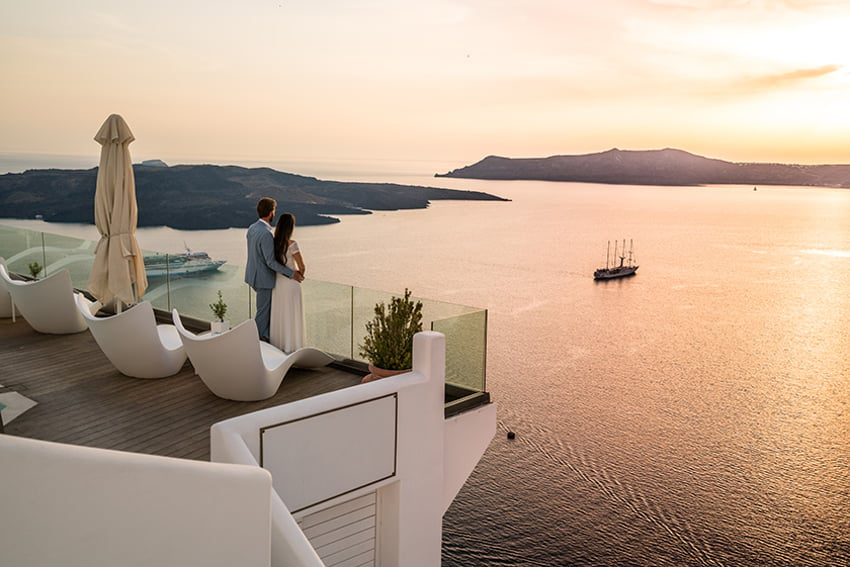 Couple dans un cadre romantique : un hôtel de luxe en Grèce qui donne sur la mer.