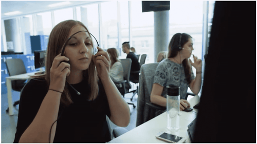 Woman putting on headset in contact center environment