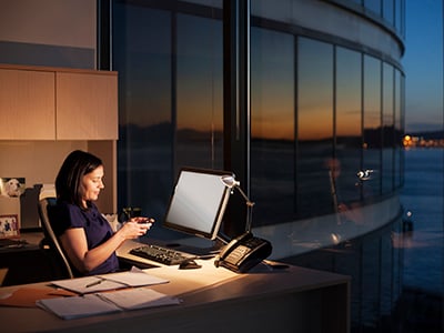 Female executive working at night with a computer in an office in Seattle, Washington, USA